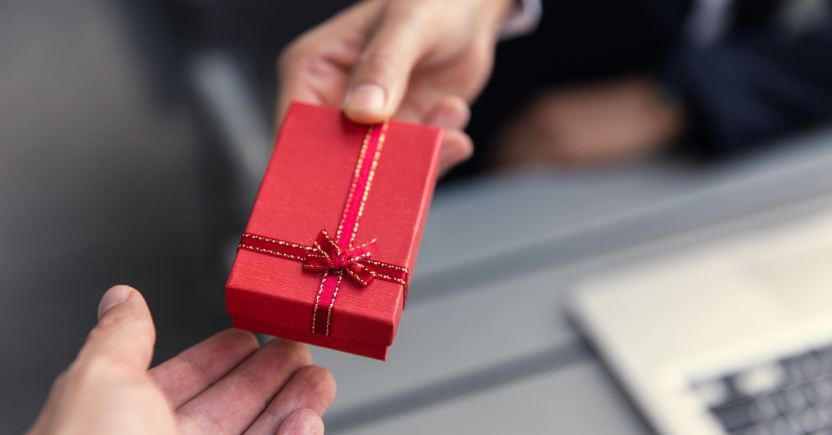 boss giving present gift box to office staff partner