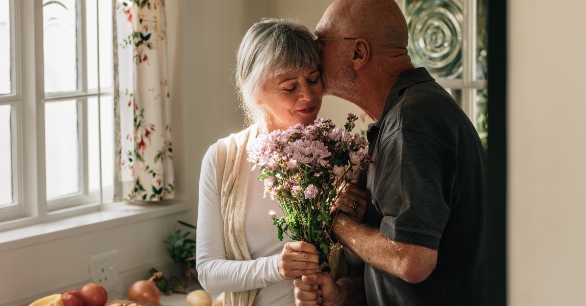 romantic senior couple at home expressing their love