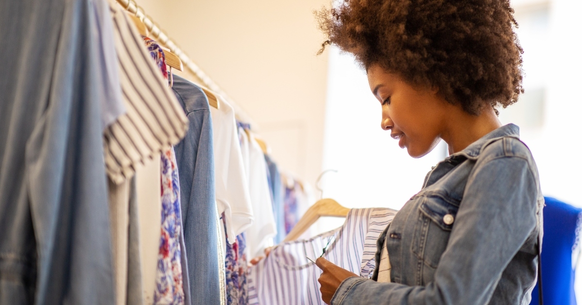 woman with afro shopping for clothes in store