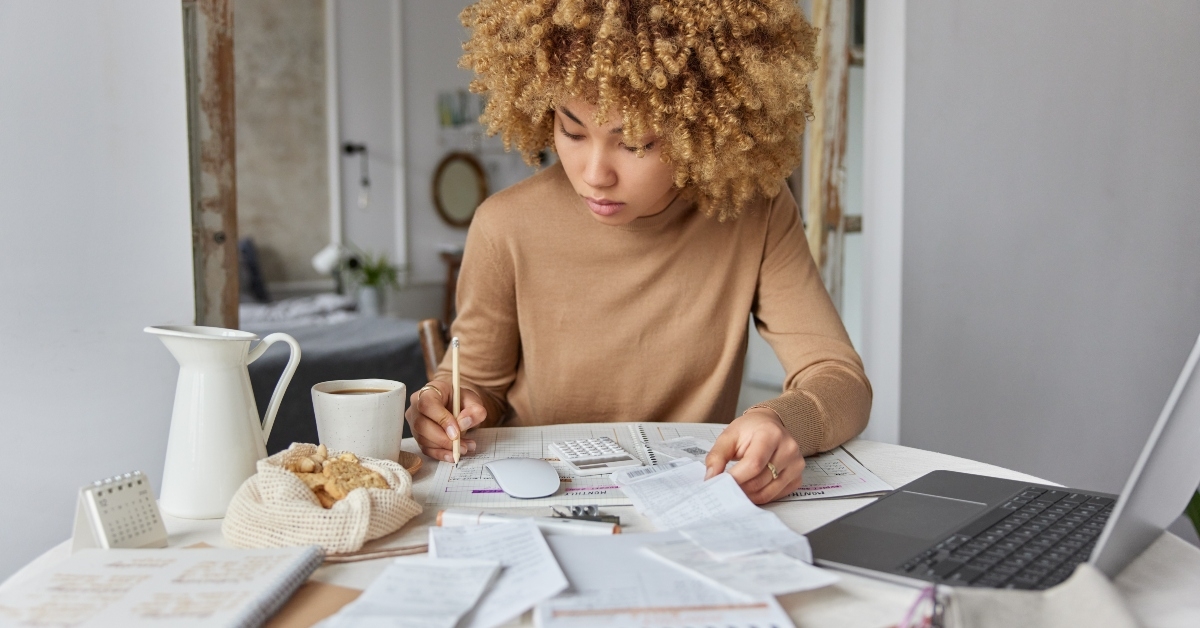 woman sits at desk at home manages household budget