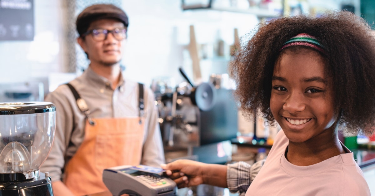 african american girl using credit card for payment at cafe 
