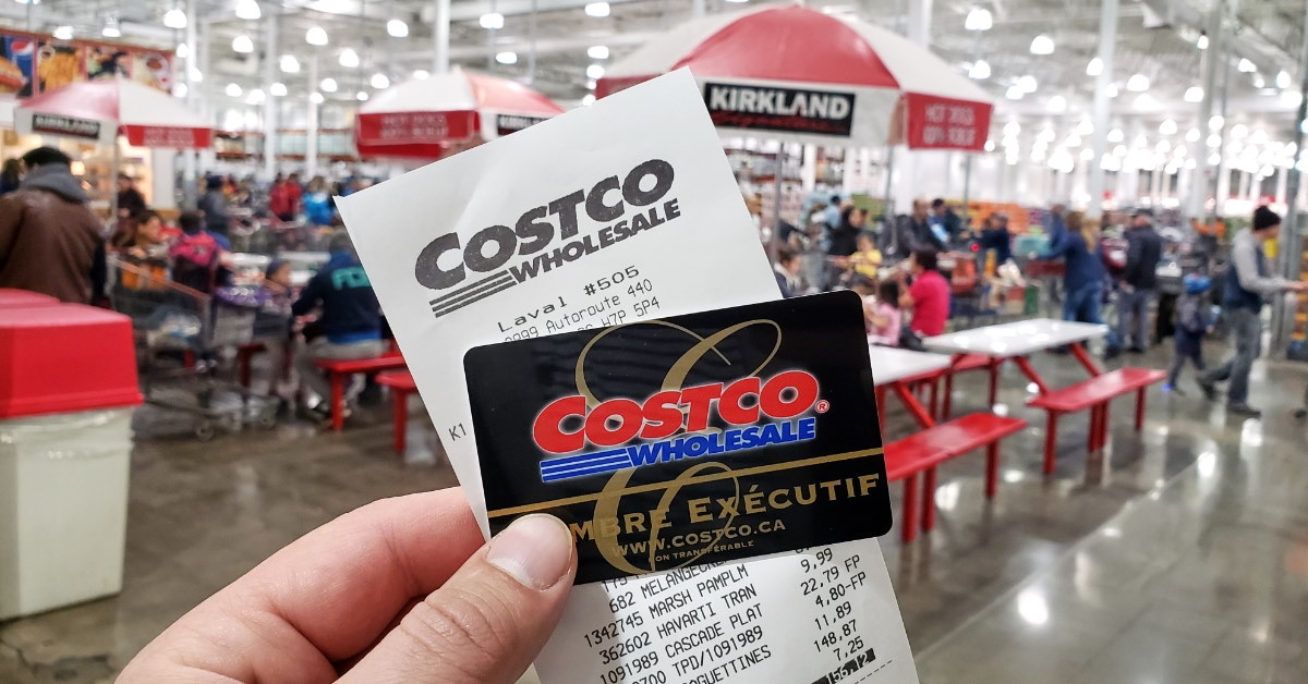 Holding Costco receipt with Executive Member card