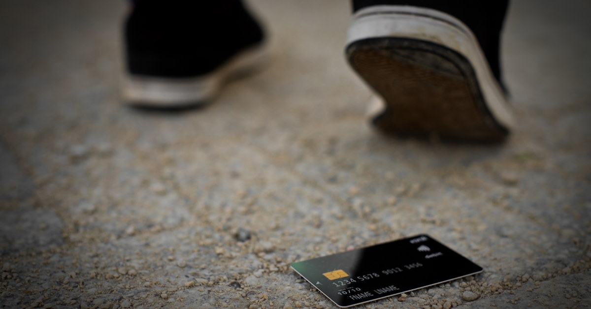 man drops credit card while walking on the road.