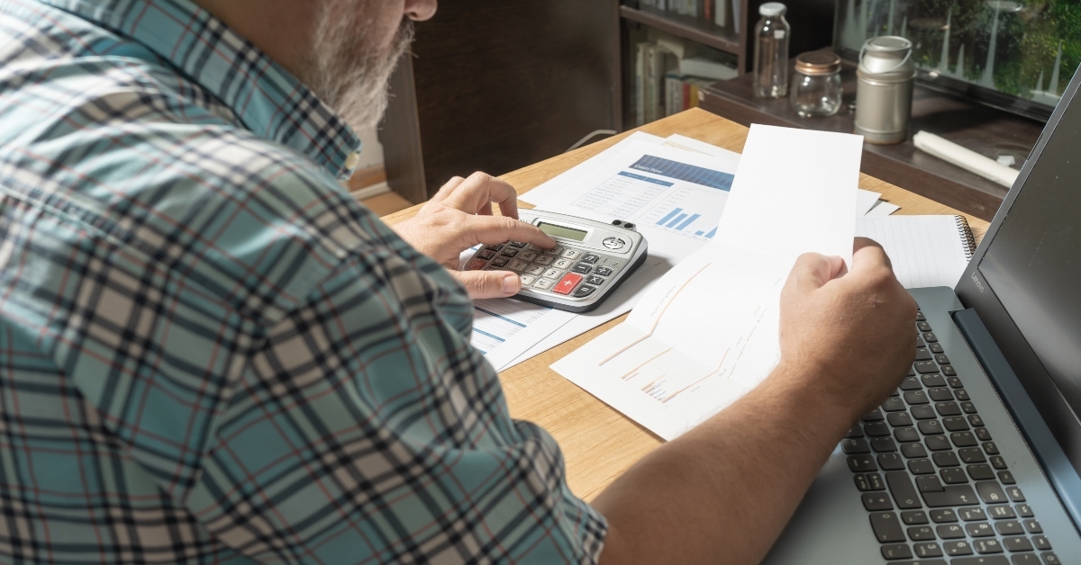 white man sitting with a sheet in his hands reviewing cash flow 