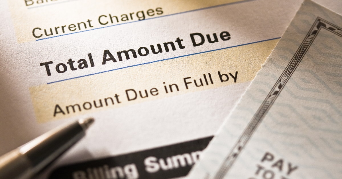 pen and cheque over credit card statement on table