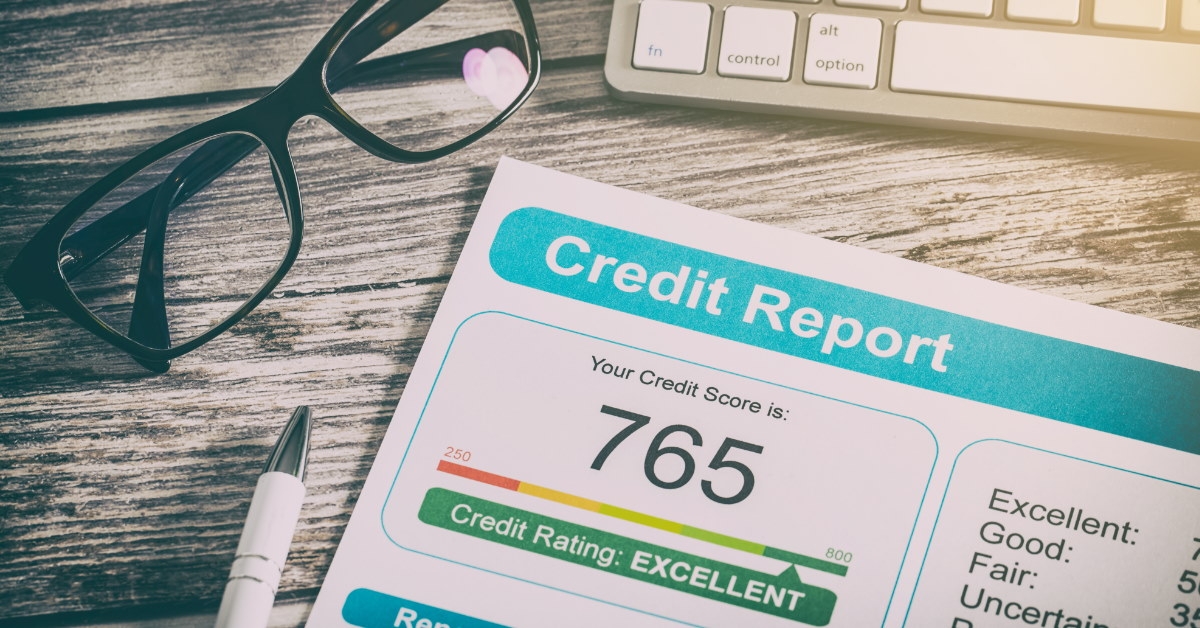 credit score written over paper placed on table with glasses and keyboard