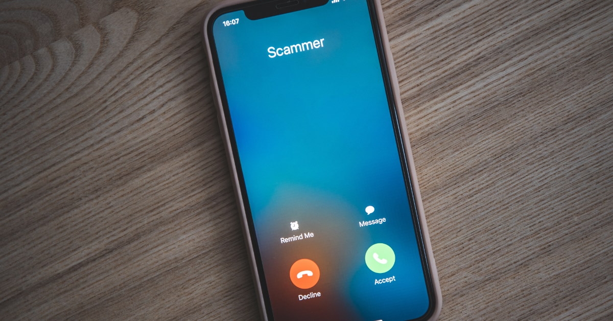 scammer calling on smartphone placed on a wooden table