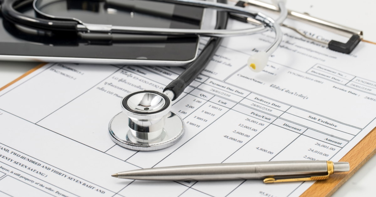 pen with stethoscope over medical billing statement at clinic