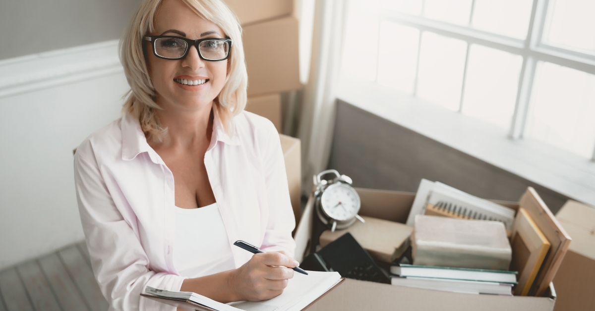 smiling blond woman with glasses with notebook