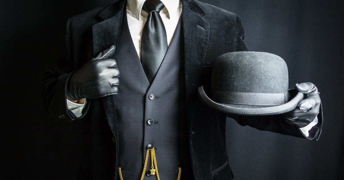 businessman in leather gloves holding bowler hat