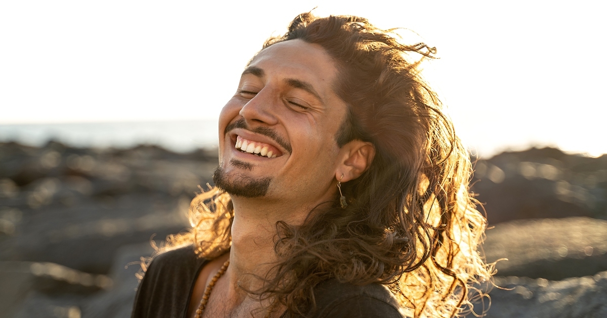handsome hippie man with long hair smiling