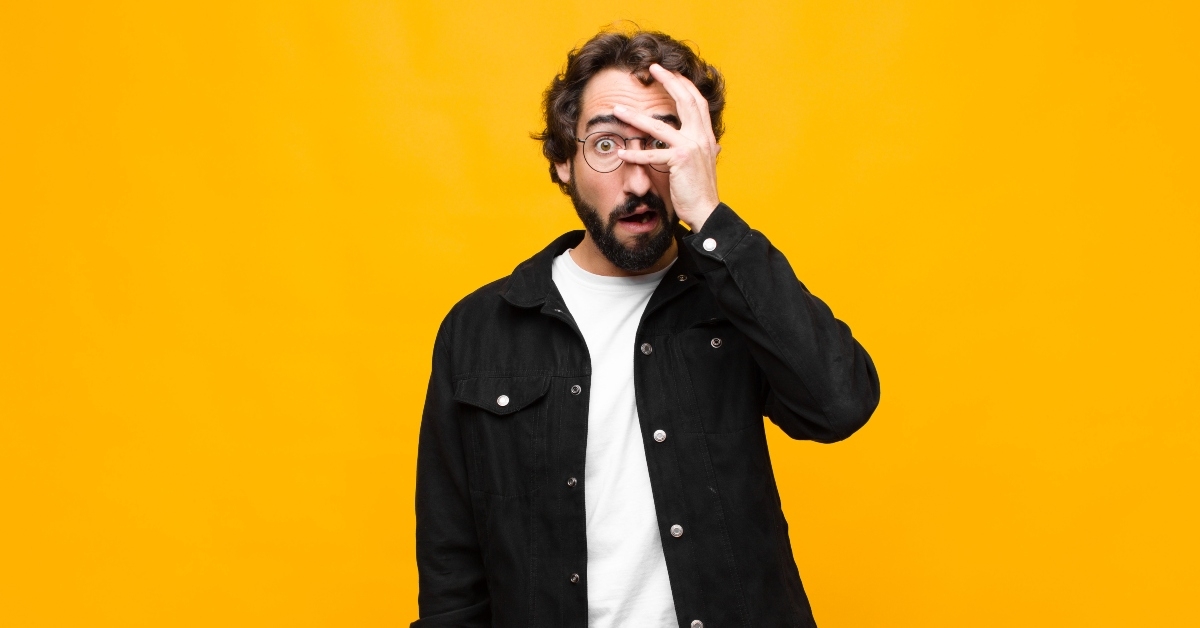 man covering face with hand
