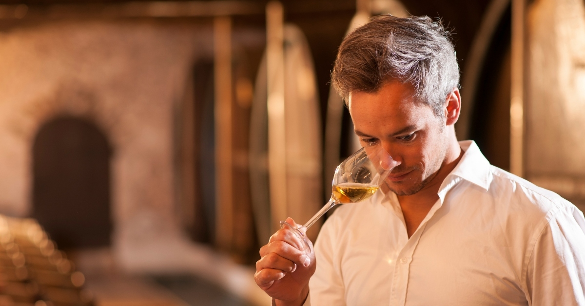 winemaker smelling a glass of white wine