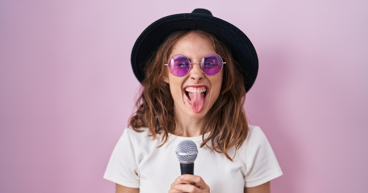 woman singing song using microphone sticking tongue out
