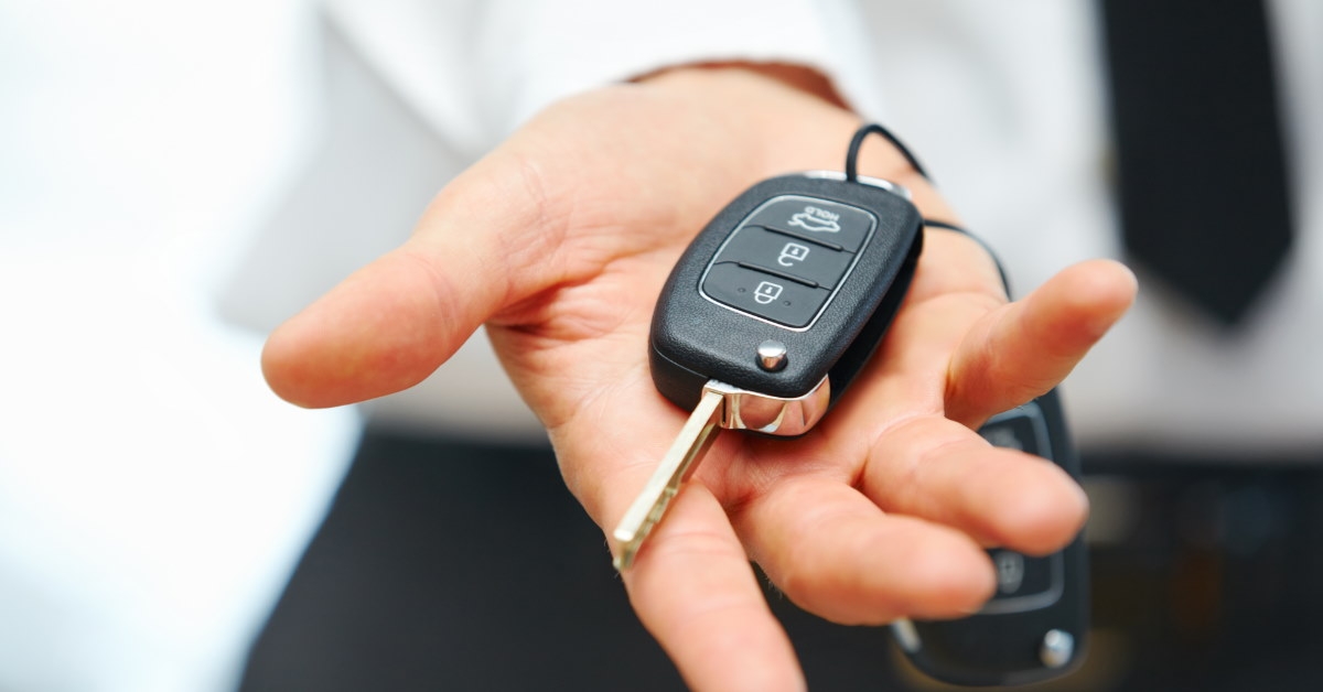 man holding car keys with remote in hand