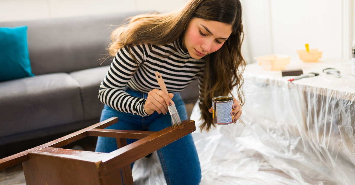 woman using brush to polish furniture at home