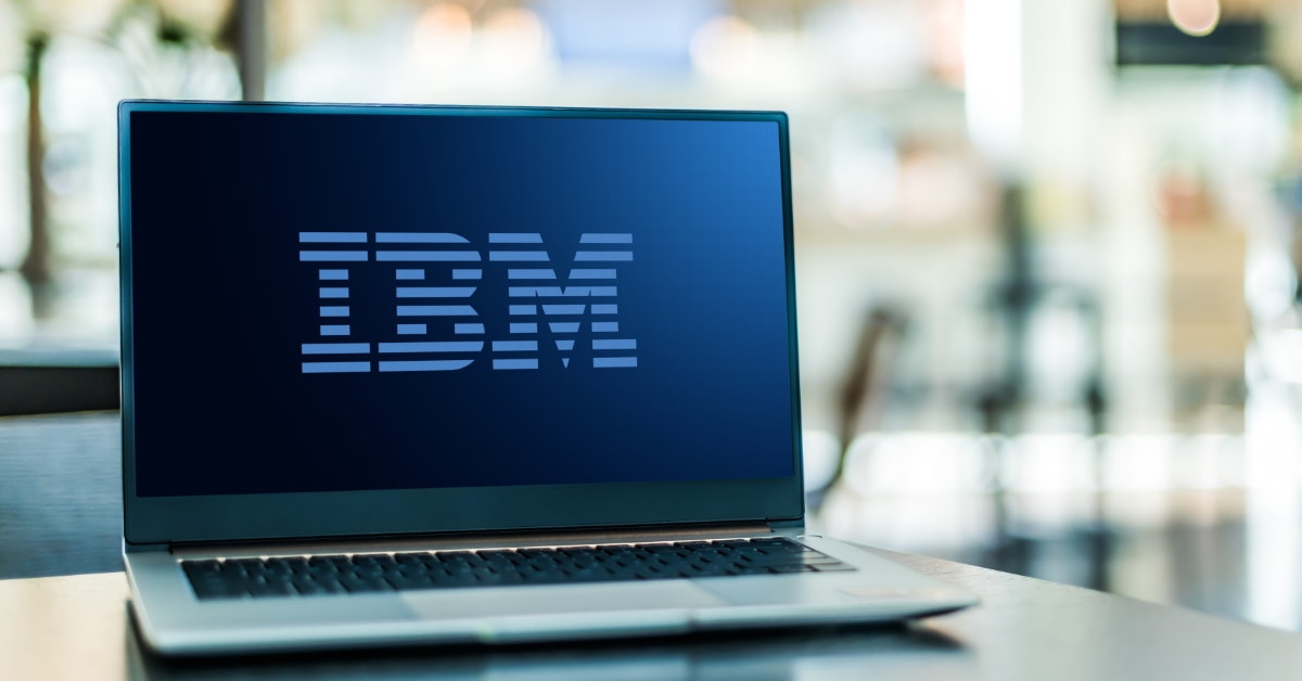 table having laptop with huge ibm logo over black background