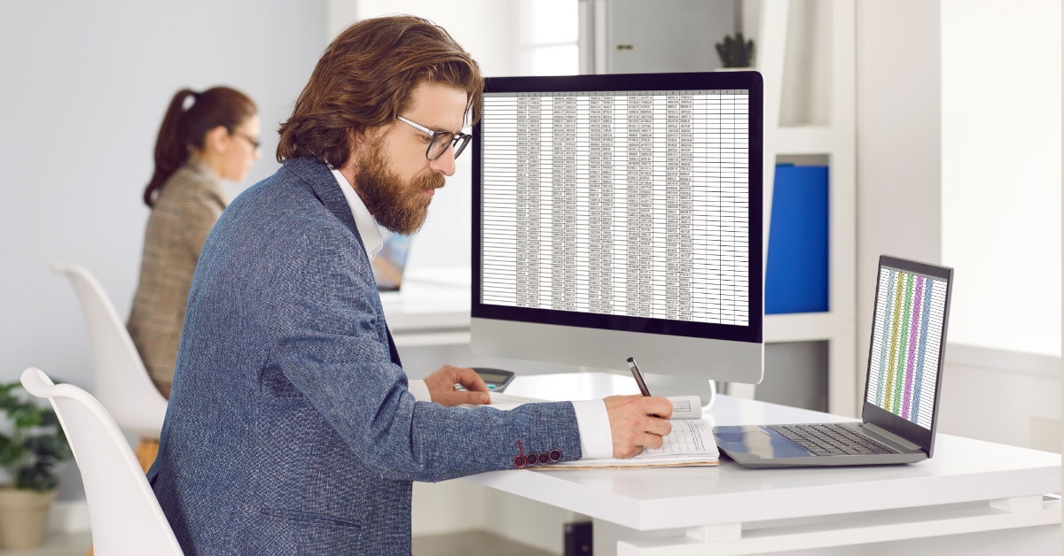 male accountant wearing suit writing on notebook in office
