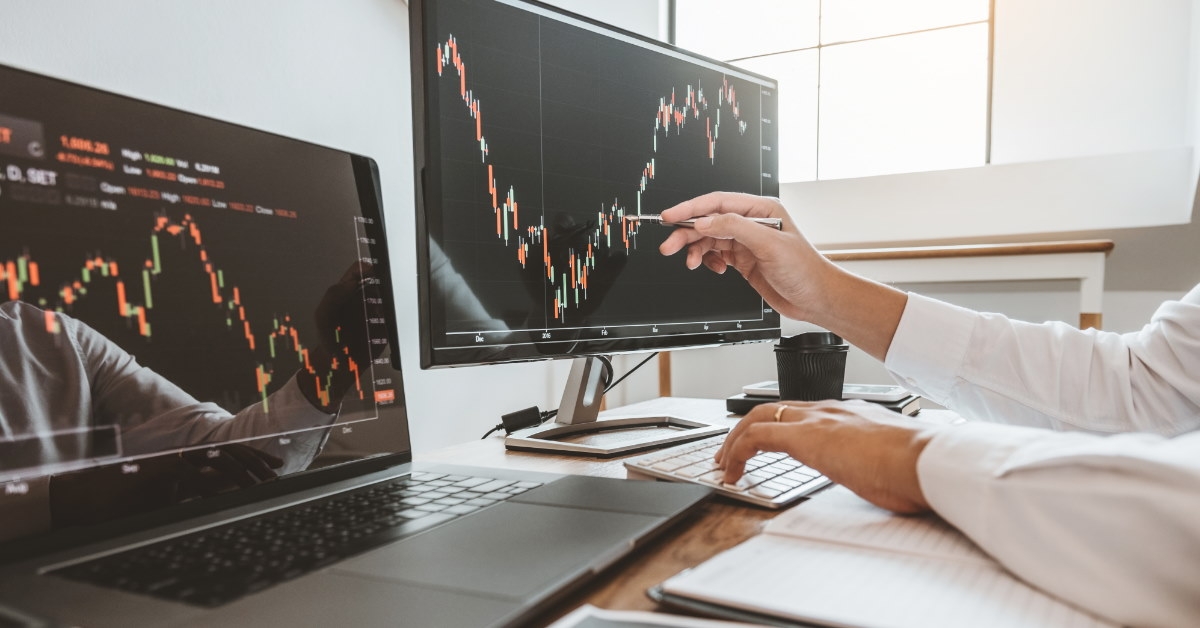 man checking stock graphs on monitor 