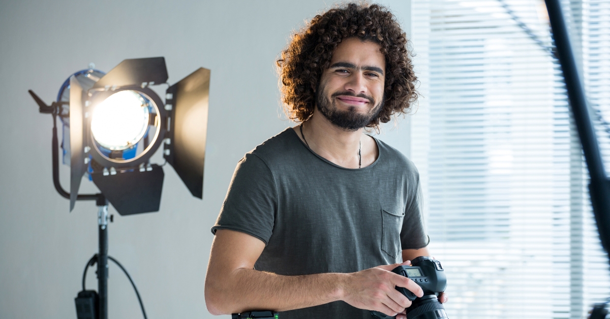 happy male photographer standing in studio 