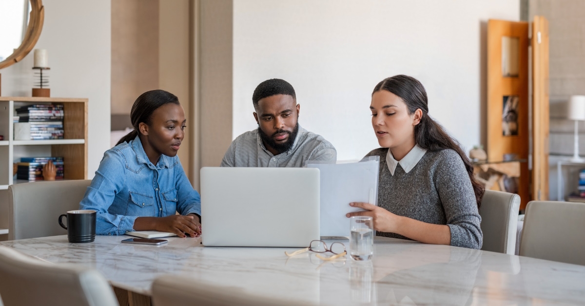 african american couple taking advice from female finance advisor 