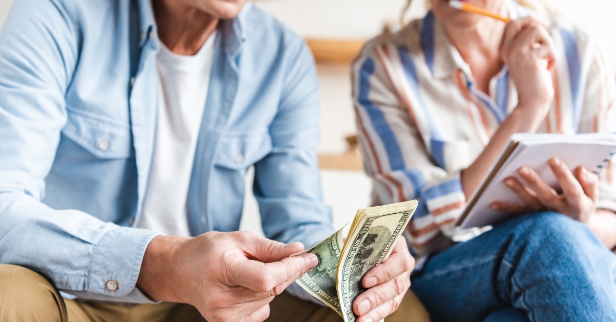 senior couple sitting at home as counting money 