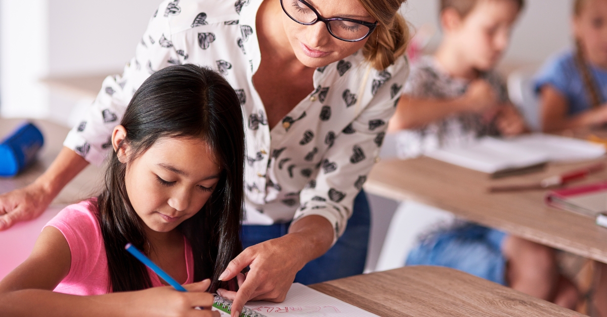teacher helping girl in homework