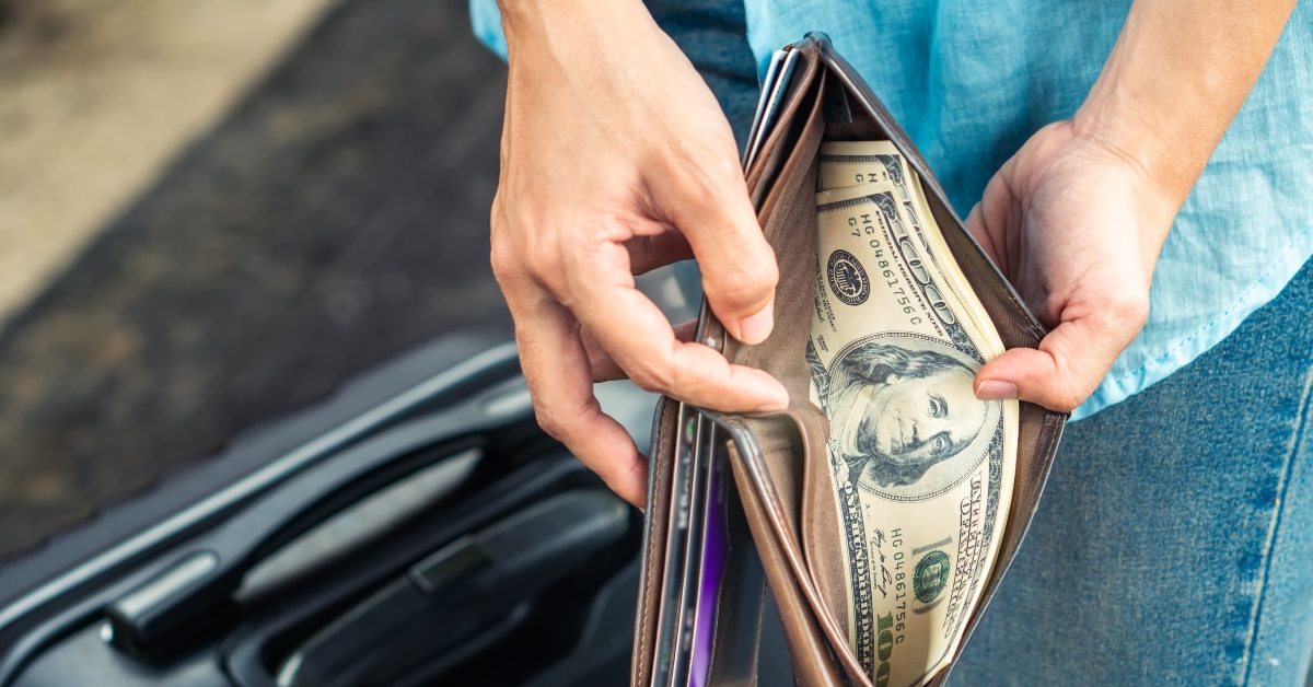 woman hands holding a wallet with dollar currency
