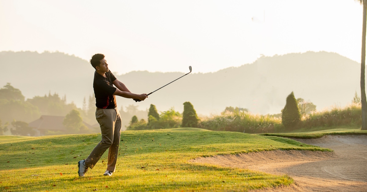 man wearing shorts playing golf
