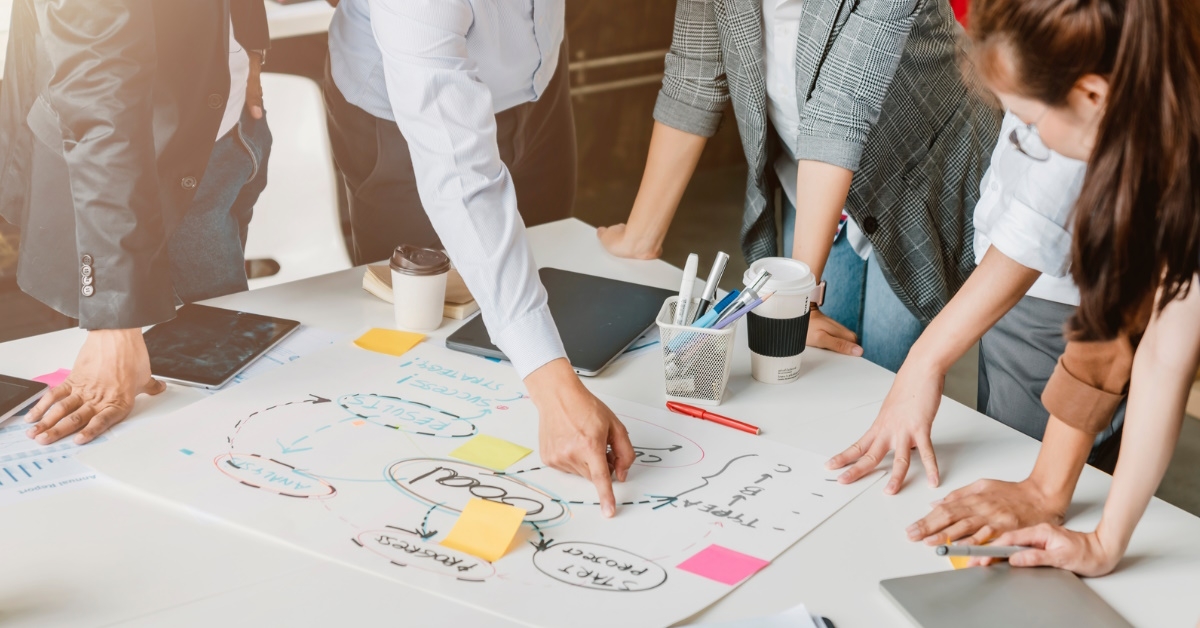 business team gathered together at table discussing plan on chart