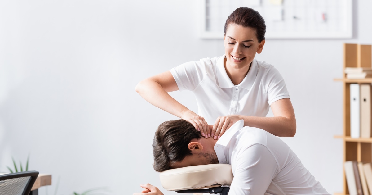 female masseuse giving back massage to man 