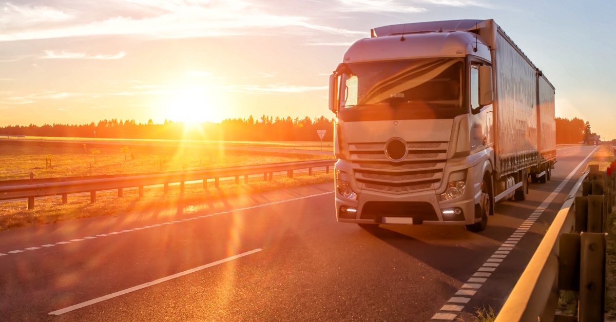 modern wagon truck standing on road with sunset as backdrop