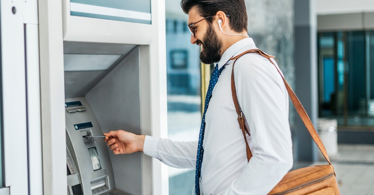 businessman taking out money from atm
