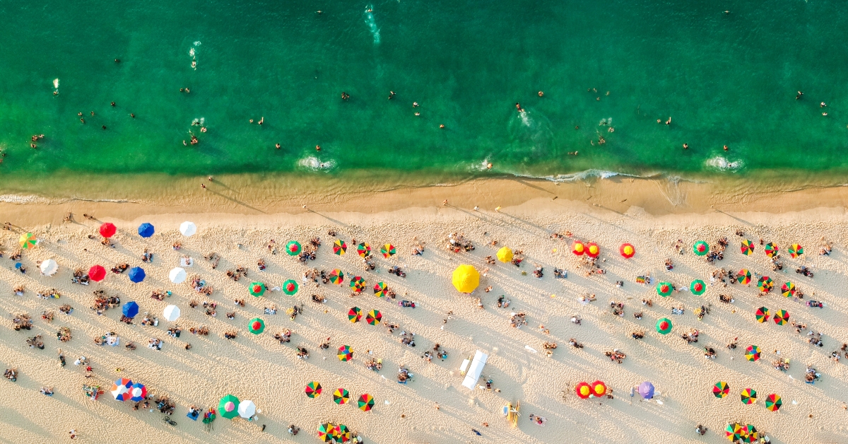 beach with colorful umbrellas people swimming in the sea