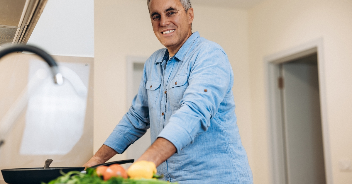 man stands near stove waits for the dish to be ready