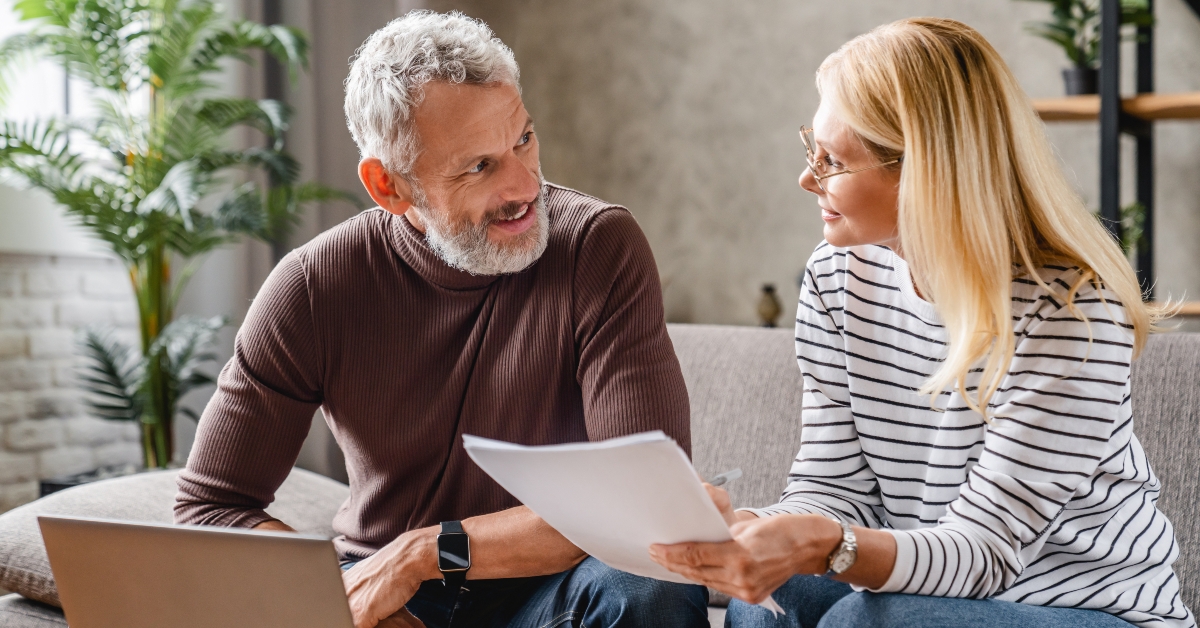 middle aged couple with laptop studying documents