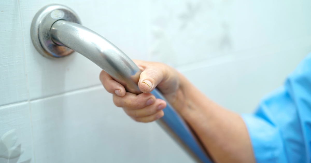 old woman patient uses toilet handle