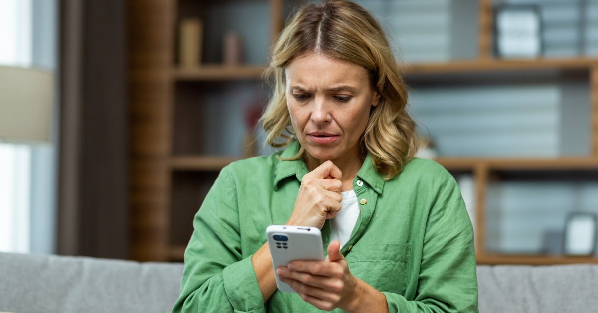 upset senior woman holding phone