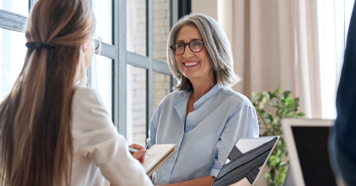 female hr manager standing in front of young female assistant at office