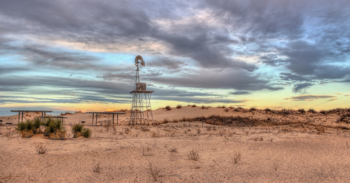 vacant windmills near midland odessa texas with barren land 