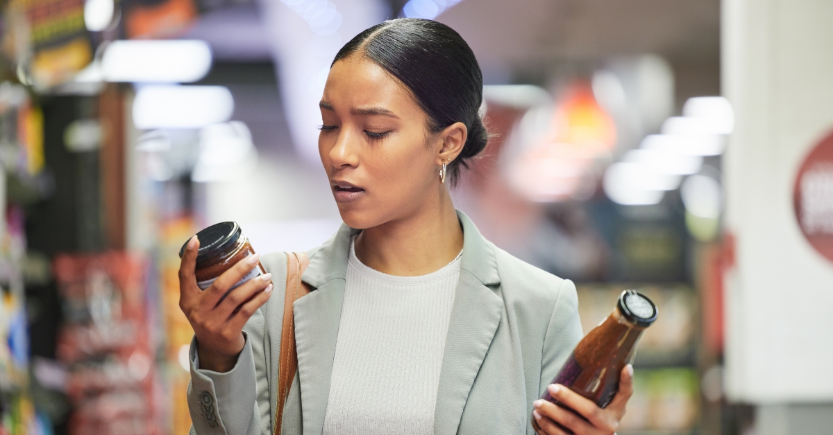 female shopper comparing sauce bottles