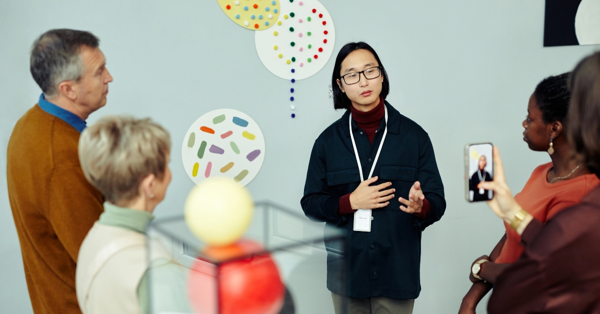 gallery worker standing in front of group of tourists
