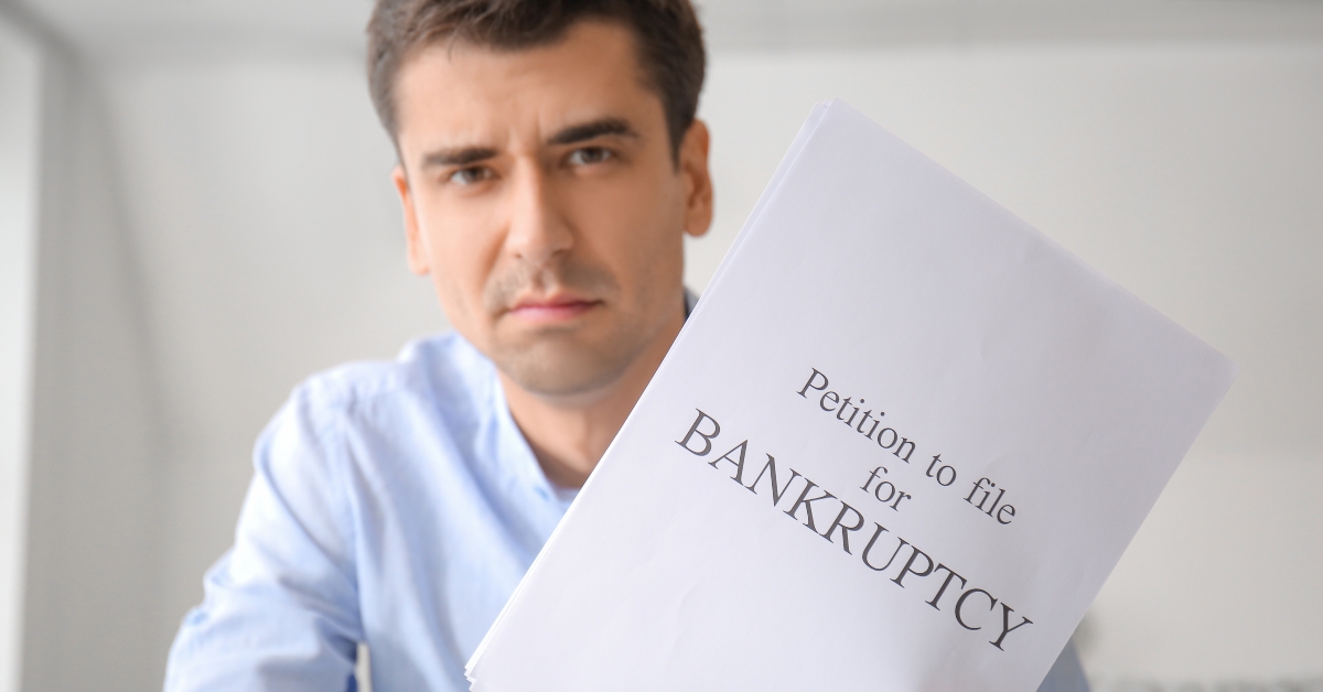 stressed man with petition to file for bankruptcy at home