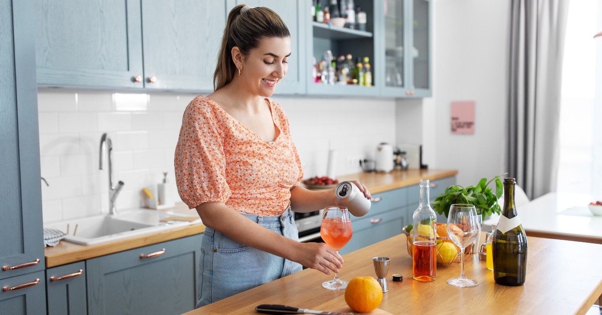 young woman making orange cocktail