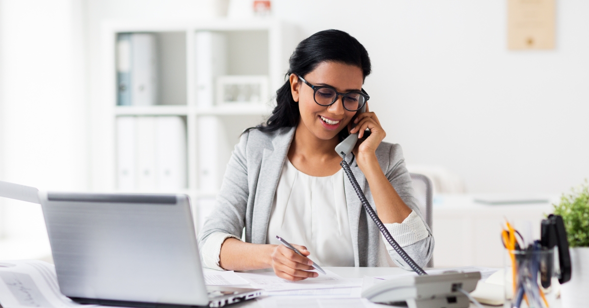 happy businesswoman calling on phone at office