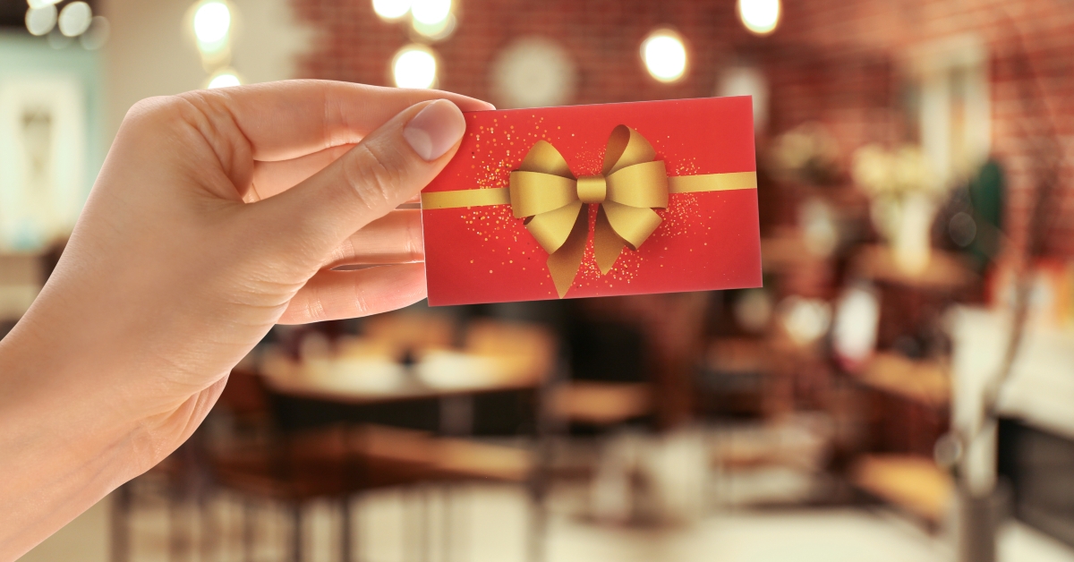 woman holding gift card in restaurant