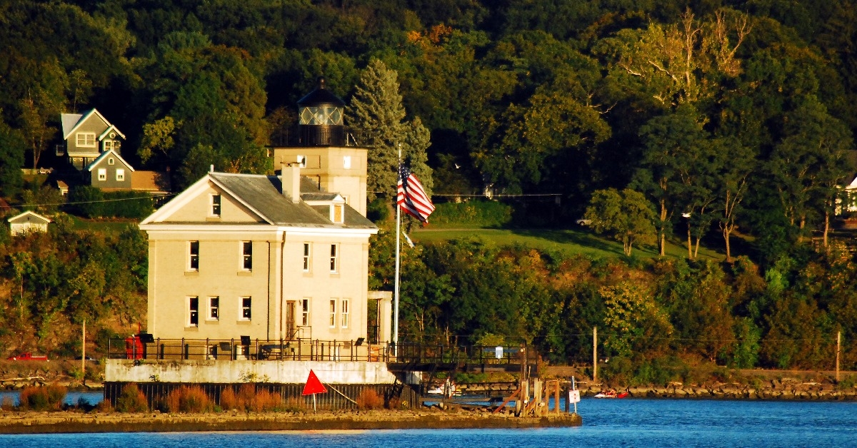 rondout lighthouse on the bank of hidson river with us flag during day time