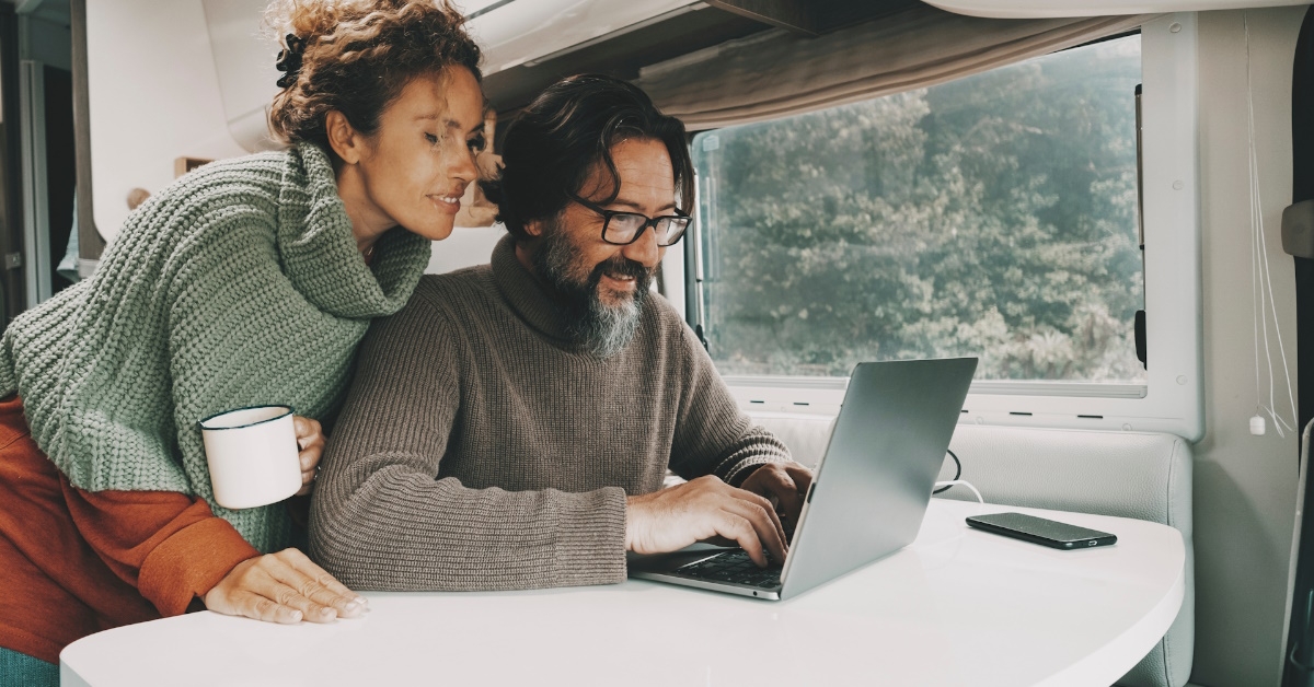 couple sitting in rv using laptop