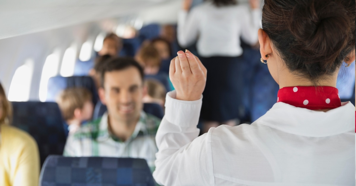 female flight attendant using hand gestures to guide passengers 