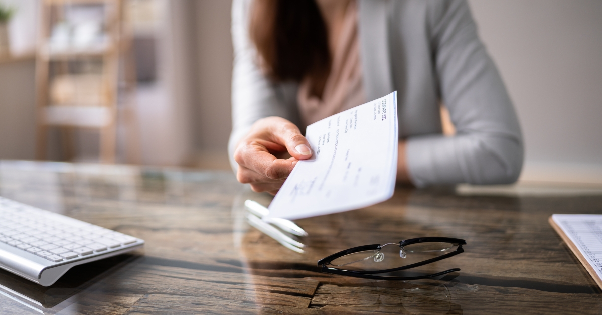 businessperson's hand holding cheque